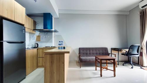 a kitchen with a refrigerator and a table and a chair at Palam Mansion at Apartment One Residence in Batam Center