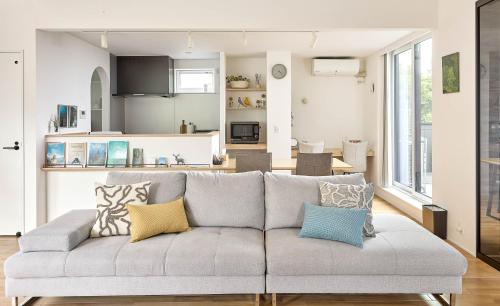 a living room with a gray couch with colorful pillows at KeiU-Yakushima Guest House in Yakushima