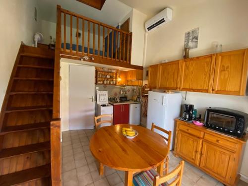 une cuisine avec une table en bois et un réfrigérateur dans l'établissement Port Leucate: Charmante Villa 4 Pers. Proche Lac, Terrasse, Parking, Animaux Acceptés - FR-1-798-49, à Leucate