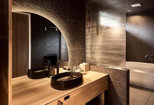 a bathroom with two sinks and a mirror at KeiU-Yakushima Guest House in Yakushima