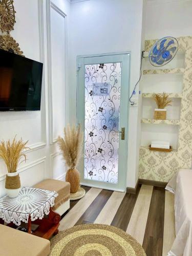 a living room with a door with a floral pattern at Hoàng Nga 2 Homestay in Phan Thiet