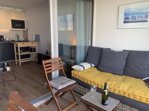 un salon avec un canapé et une chaise dans l'établissement Studio Contemporain - 2/4 pers - Centre de la Station - Parking Sécurisé - FR-1-796-60, à Gruissan