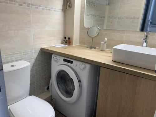 une salle de bain avec une machine à laver et un lavabo dans l'établissement Studio Contemporain - 2/4 pers - Centre de la Station - Parking Sécurisé - FR-1-796-60, à Gruissan