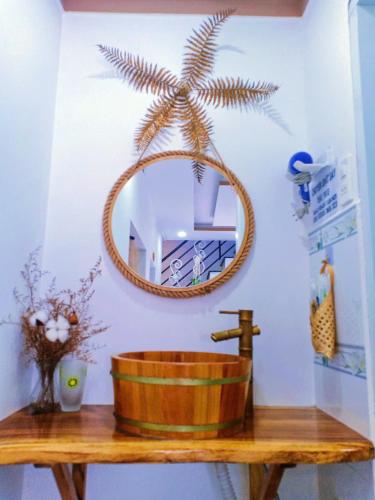 a bathroom with a wooden tub and a mirror at Hoàng Nga 2 Homestay in Phan Thiet