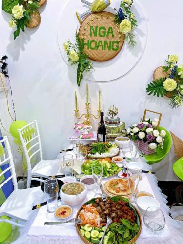 a table with plates of food and a bottle of wine at Hoàng Nga 2 Homestay in Phan Thiet