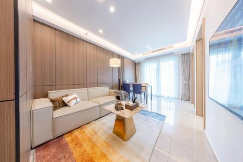 a living room with a white couch and a table at Excellence International Apartment - Convention & Exhibition Center in Shenzhen