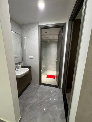 a bathroom with a shower and a sink and a mirror at Bintang Family suite at Agile TRX by KL in Kuala Lumpur