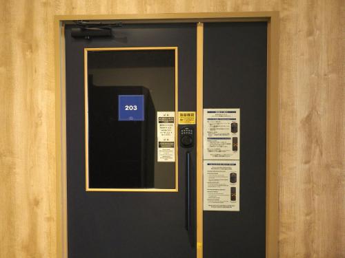 a door with a sign in front of it at マーケットステイ新宮 in Shingu