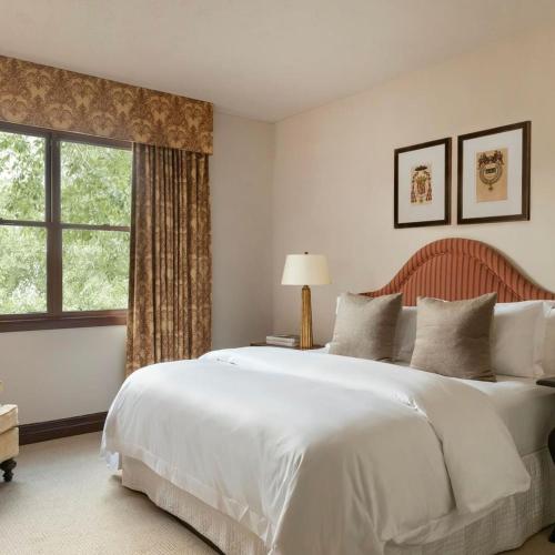 a bedroom with a large white bed and a window at Hotel Granduca Houston in Houston
