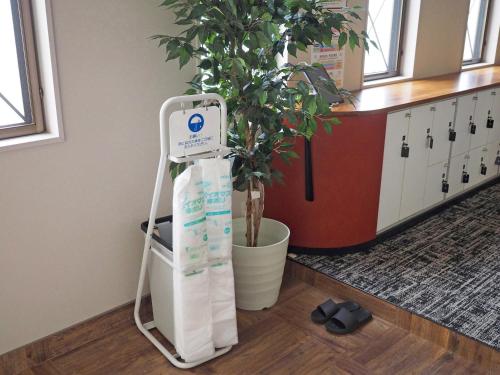 a plant on a stand in a room with a plant at マーケットステイ新宮 in Shingu