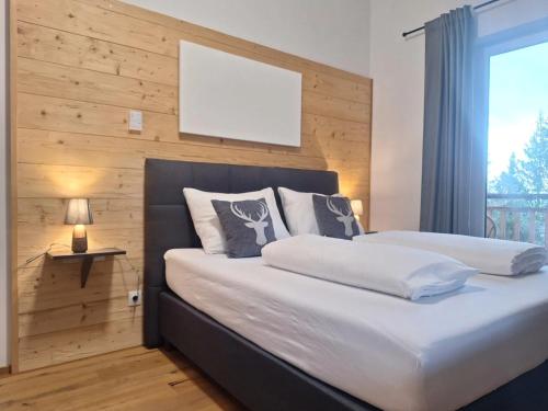 a bedroom with two beds with a wooden wall at Chalet in Turracher Höhe with Ski Slope Access in Turracher Hohe