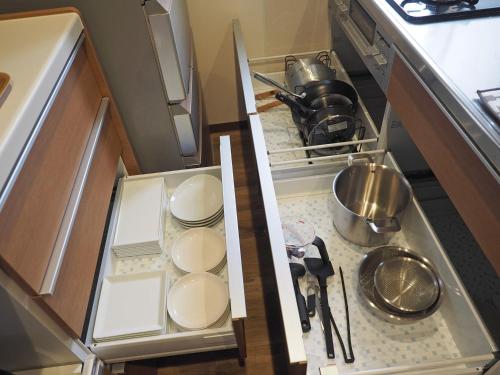 an open drawer in a kitchen with dishes in it at マーケットステイ新宮 in Shingu
