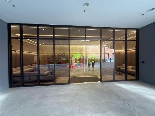 a large glass door in a building with people in it at Bintang Family suite at Agile TRX by KL in Kuala Lumpur