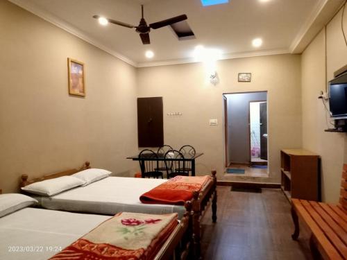 a bedroom with two beds and a ceiling fan at River View Homestsy in Vālpārai