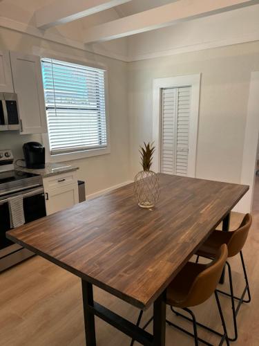a kitchen with a wooden table and two chairs at Mid-Century 1bd House - Beach Gear - 5min Walk to Beach in Clearwater Beach