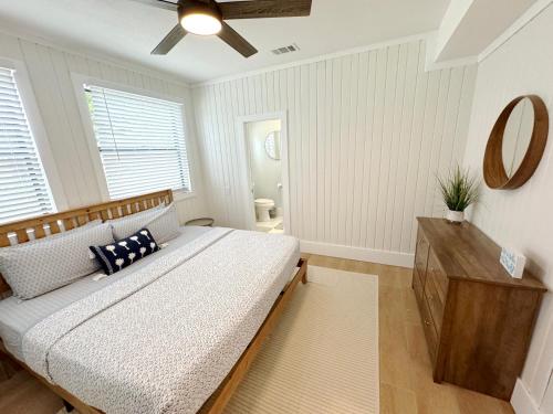 a bedroom with a bed and a dresser and a mirror at Mid-Century 1bd House - Beach Gear - 5min Walk to Beach in Clearwater Beach