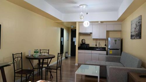 a living room and kitchen with a couch and a table at Davao Central Suites in Davao City