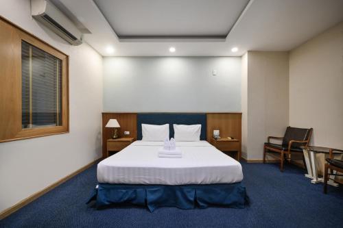 a hotel room with a bed and two chairs at Sunshine Airport Hotel in Ho Chi Minh City