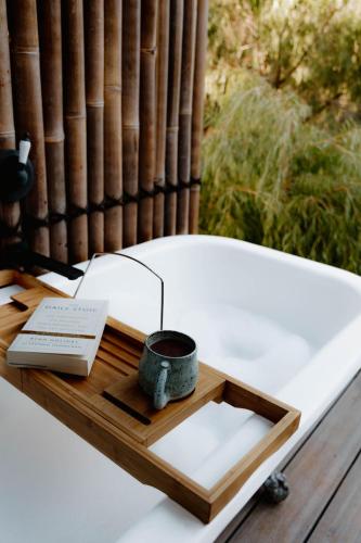 a wooden tray with a candle and a book on a table at R&R Bus Retreat in Wellington Mills