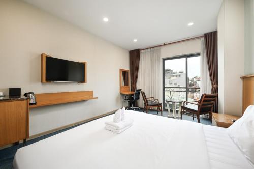 a hotel room with a bed and a flat screen tv at Sunshine Airport Hotel in Ho Chi Minh City