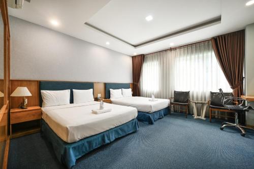 a hotel room with two beds and a desk at Sunshine Airport Hotel in Ho Chi Minh City