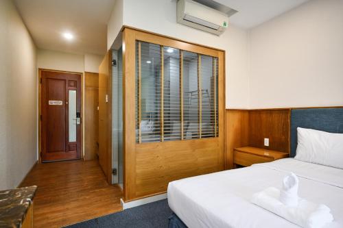 a hotel room with a bed and a window at Sunshine Airport Hotel in Ho Chi Minh City