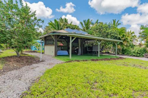a gazebo with a bed and a tree at Glamping Garden Getaway in Kalapana Sea View Estates