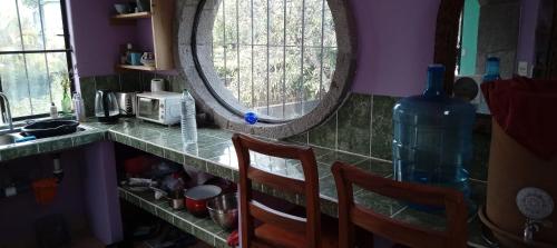 a kitchen with a counter with two chairs and a mirror at Lakeview Villa Santiago 2 in Santiago Atitlán