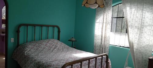 a bedroom with a bed and a blue wall at Lakeview Villa Santiago 2 in Santiago Atitlán
