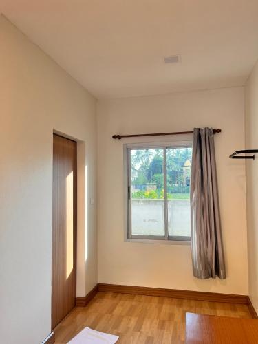 an empty room with a window and a wooden floor at ศรีสุภาวดีรีสอร์ท-Srisupawadee resort in Prachuap Khiri Khan