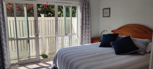 a bedroom with a bed and a large window at Fairburn Hideaway in Cambridge