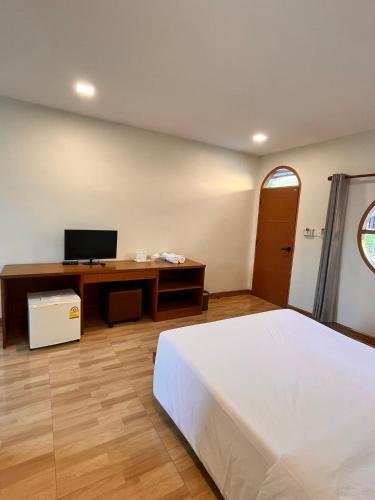 a bedroom with a bed and a desk with a television at ศรีสุภาวดีรีสอร์ท-Srisupawadee resort in Prachuap Khiri Khan
