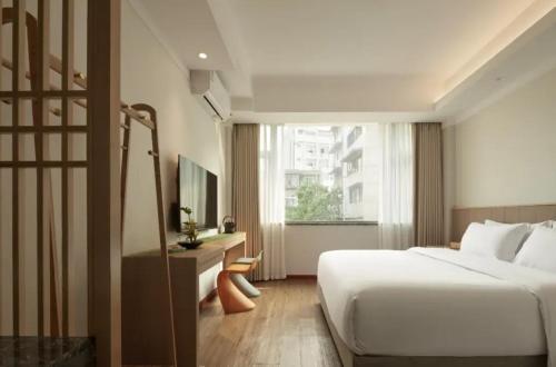 a hotel room with a bed and a window at Yinxitang Aesthetic Life Courtyard Hotel Kuanzhai Alley People's Park Subway Station Branch in Chengdu