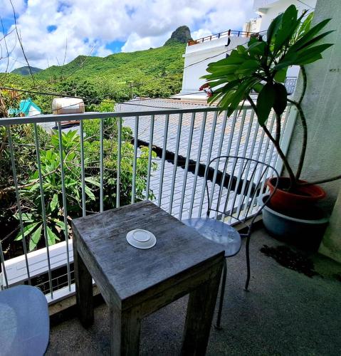 a wooden table sitting on a balcony with a plant at 墾丁橘月Orange Moon Inn in Kenting