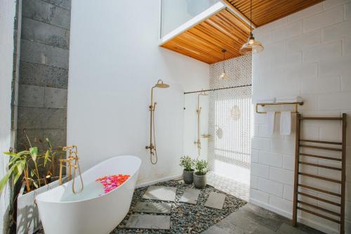 a bathroom with a white tub and a shower at Perolas Villas Resort - Ke Ga Bay in Phan Thiet