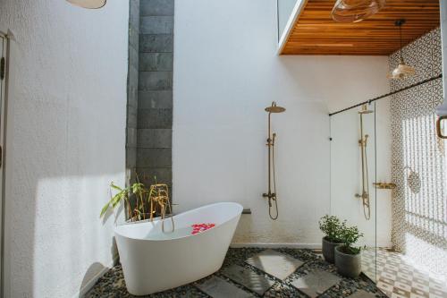 a bathroom with a white tub and a shower at Perolas Villas Resort - Ke Ga Bay in Phan Thiet