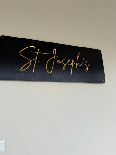 a black sign with gold writing on it at Joseph's Residency Homestay in Podanūr
