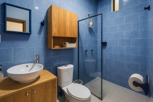 ein blau gefliestes Badezimmer mit Toilette und Waschbecken in der Unterkunft Sunset Suites in Brisas de Zicatela