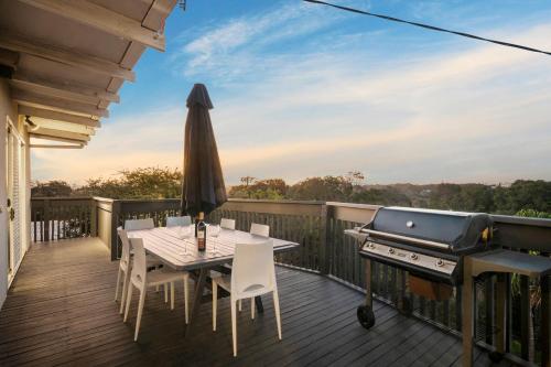 a deck with a grill and a table and chairs at Valentine Sandcastles - Your Group Beach Escape! in Rye