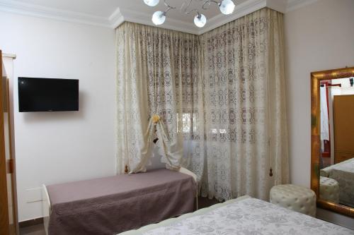 a room with two beds and a window with curtains at Palazzo Primavera in Porto Cesareo