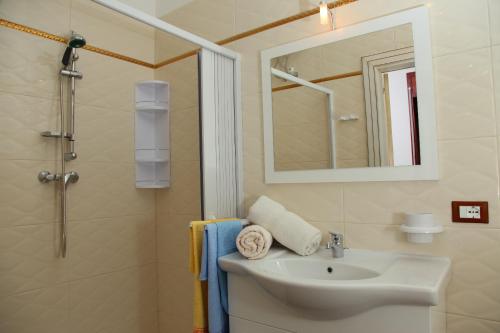 a bathroom with a sink and a shower with a mirror at Palazzo Primavera in Porto Cesareo