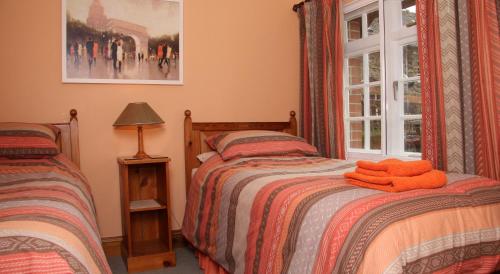 a bedroom with two beds and a window at Budleigh Farm Cottages in Moretonhampstead
