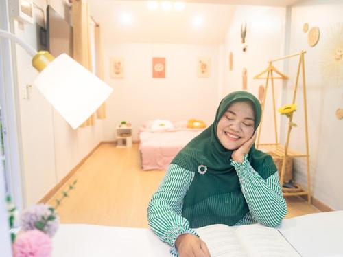 a woman sitting at a table in a room at Cana Garden Minimal 4 in Satun
