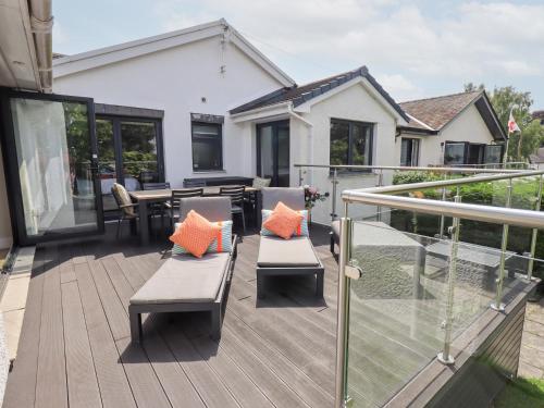 a deck with two benches and a table on a house at Yonder Lea in Windermere