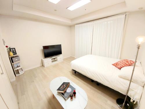 a white bedroom with a bed and a tv at 동탄 센트럴 더블퀸 하우스 in Hwaseong