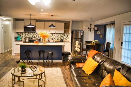 a living room and kitchen with a couch and a table at Sunshine Oasis Home in Fayetteville