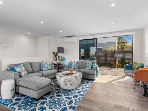 a living room with a couch and a table at Kawau Bay Escape - Snells Beach Holiday Home in Snells Beach