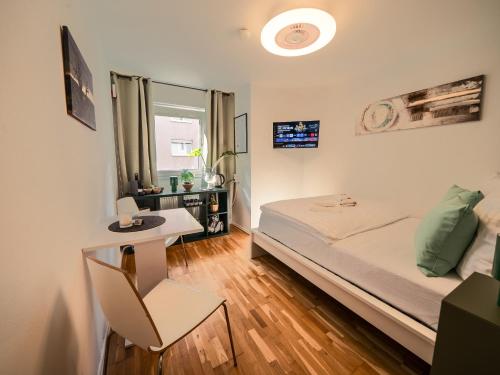 a small bedroom with a bed and a table at Green Oasis Studio - Central in Mannheim