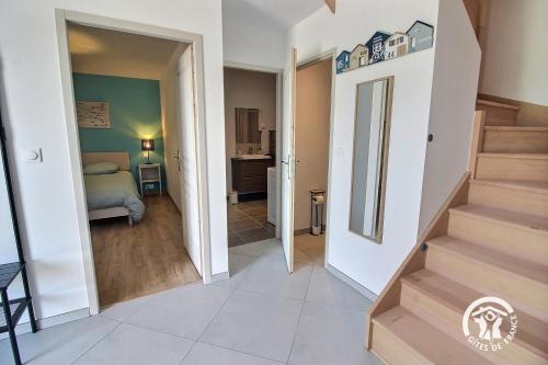 a hallway with stairs leading to a bedroom at Le ptit bois rolland in Plancoët
