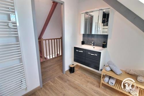 a bathroom with a sink and a mirror at Le ptit bois rolland in Plancoët